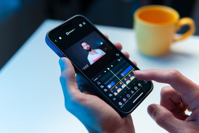 Persona editando un vídeo vertical en su teléfono móvil con los dedos sobre la línea de tiempo